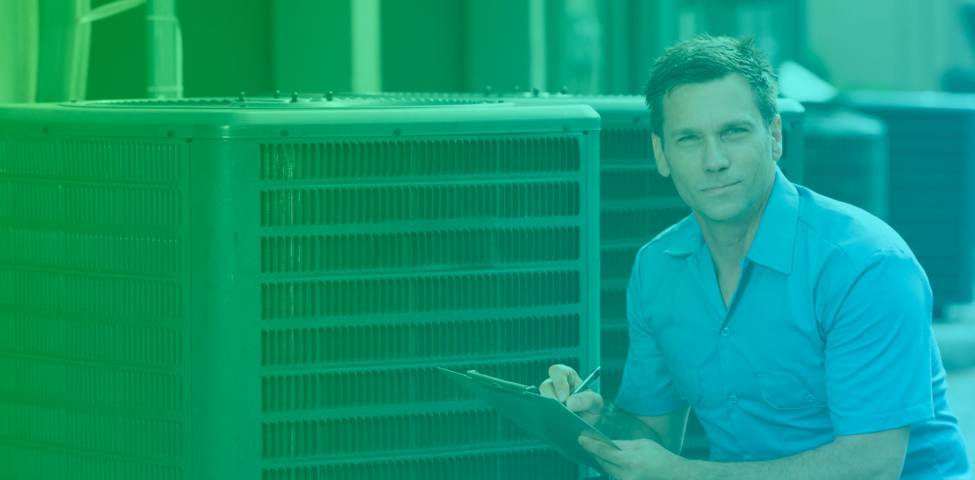Smiling man kneeling beside air conditioning unit holding a clipboard and pen